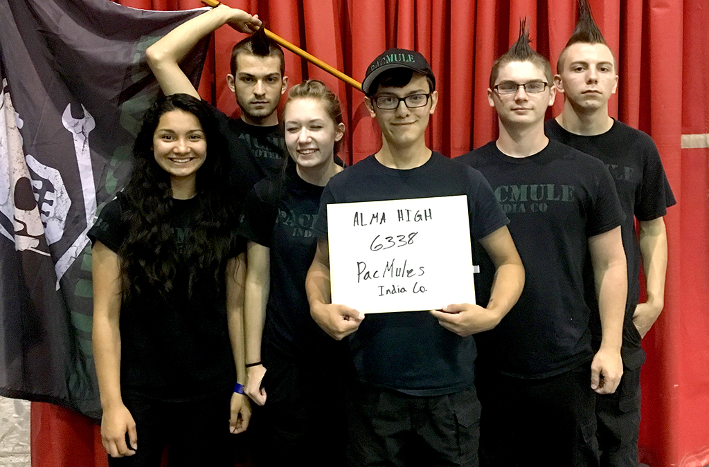 The 2017 Alma High School Tech Challenge team proudly displays their branded shirts, hats, and team flag.