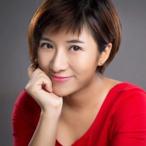 Woman with hand on chin and wearing red shirt