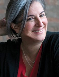 female smiling in red shirt and black jacket 
