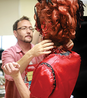 Las Vegas wig-maker and makeup artist Warren Holz fits a wig onto a student at the 2015 Thespian Festival. 